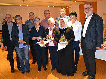 Ehrung von Freiwilligen. Ein Gruppenfoto von mehreren Menschen in einem hellen Raum.