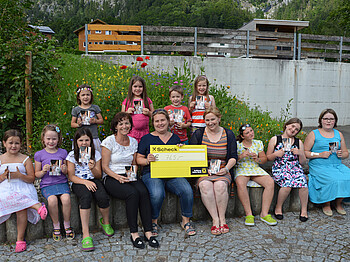 Kinderchor Montafon spendet 765 Euro für die Auslandshilfe. Gruppenfoto des Chors. In der Mitte sitzt Caritas-Mitarbeiterin Mirjam Vallaster. 