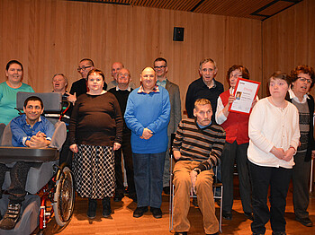 Ein Gruppenfoto bei einer Ehrung in einem hellen Raum.